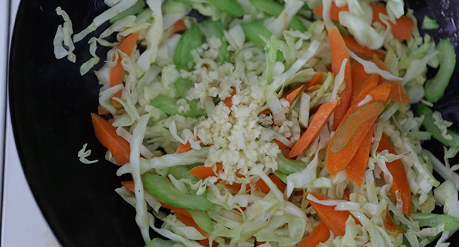 adding garlic to stir fried vegetables