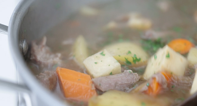 adding potatoes and carrots to lamb stew