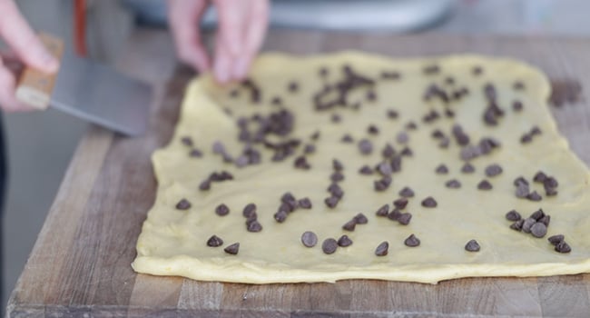 adding chocolate chips to dough