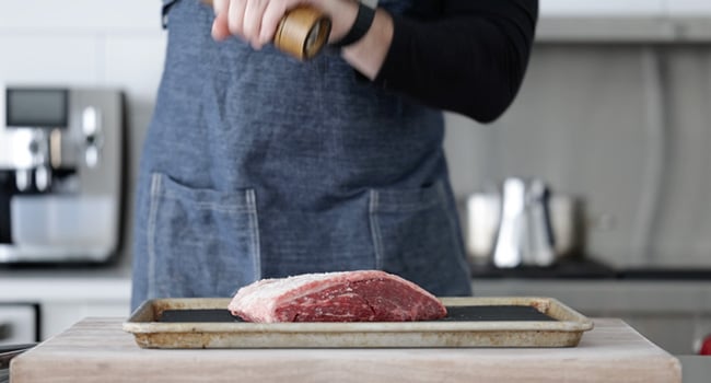 adding pepper to a picanha