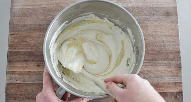 mixing whipped cream with thick custard in a bowl