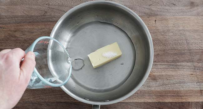 adding water to a pot with butter