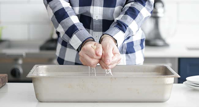 squeezing water from soaked bread