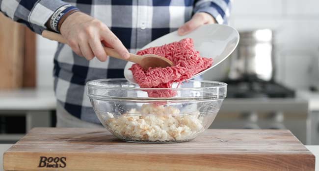 adding ground beef to a bowl