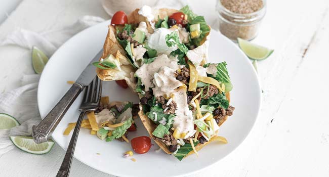 taco bowl cut in half on a plate