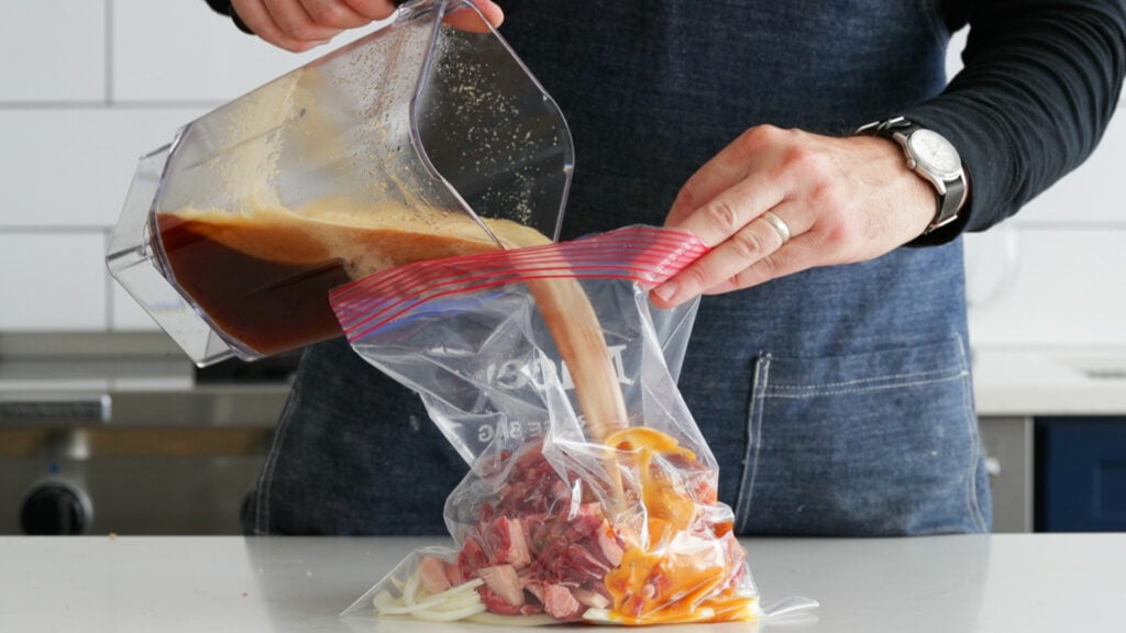 adding the marinade to bag of sliced beef and onions for beef bulgogi