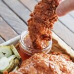 dipping a hot honey chicken tender