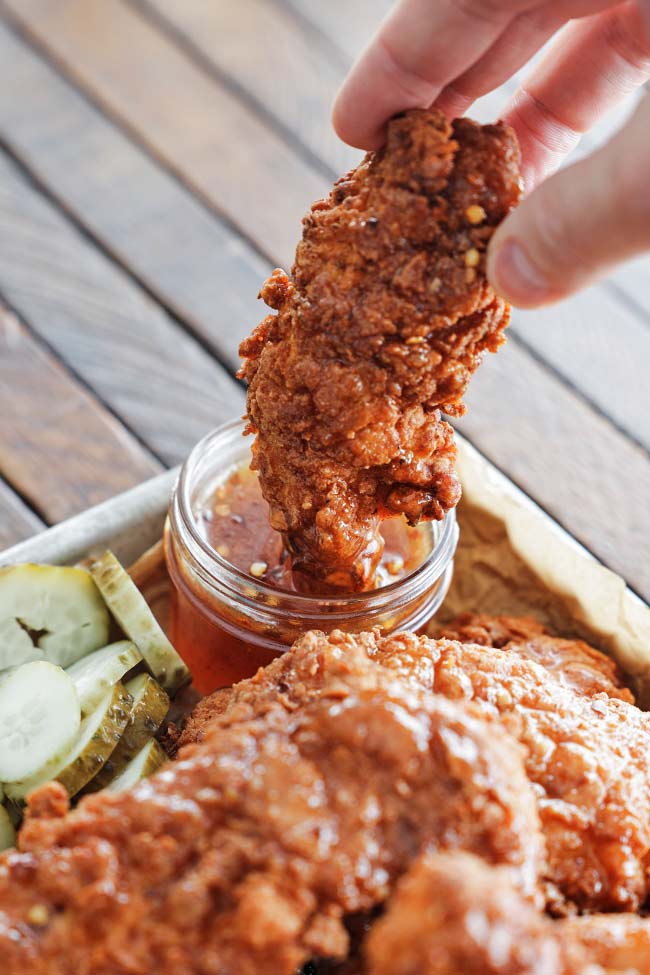 dipping a hot honey chicken tender