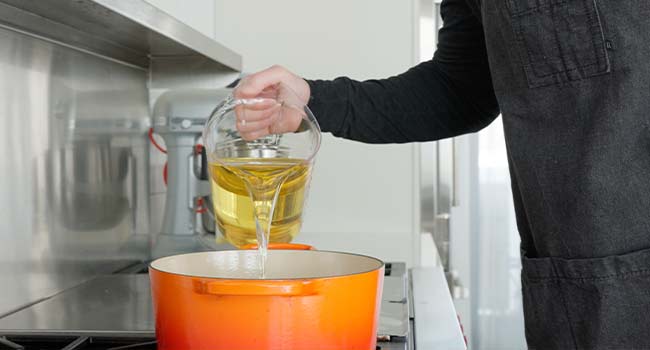 adding oil to a pot