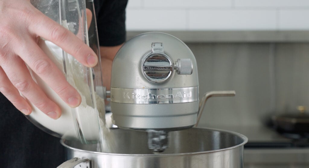adding flour to a stand mixer