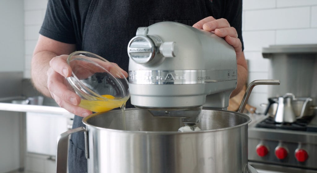 adding eggs to a stand mixer