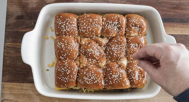 adding sesame seeds and butter to buns