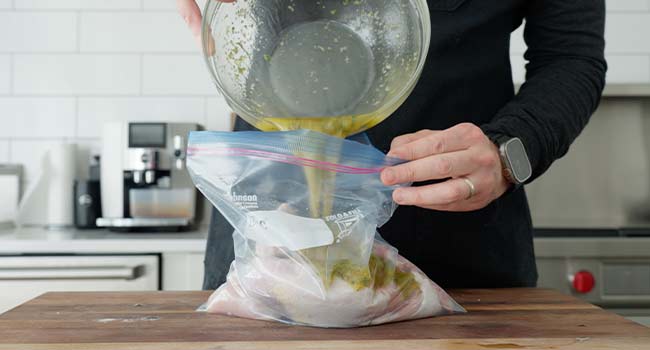 adding an italian marinade to a bag with chicken