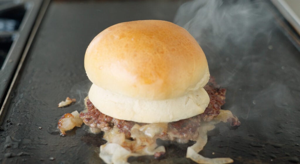 steaming burger buns on a patty