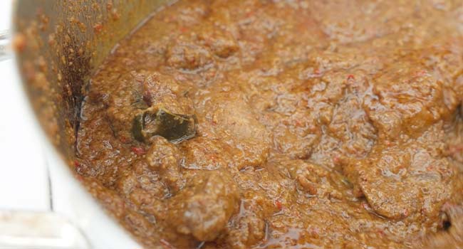 simmering beef rendang in coconut milk