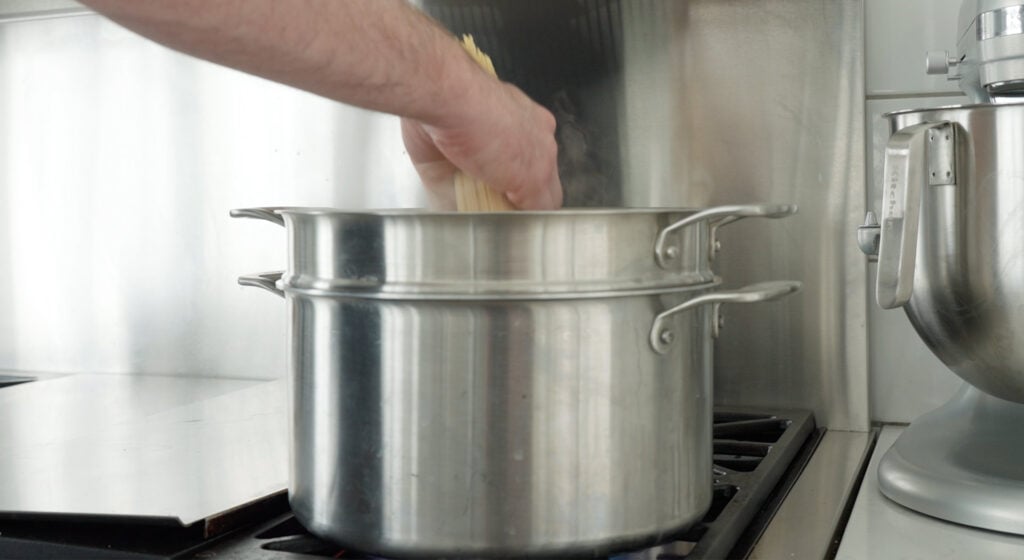 adding pasta to large pot