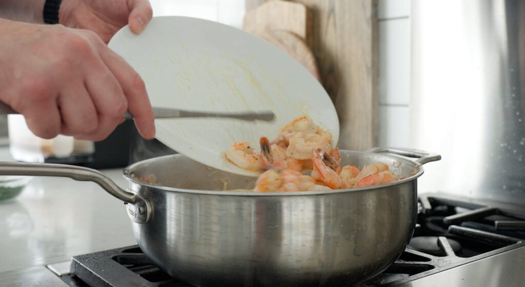 adding shrimp back into pan