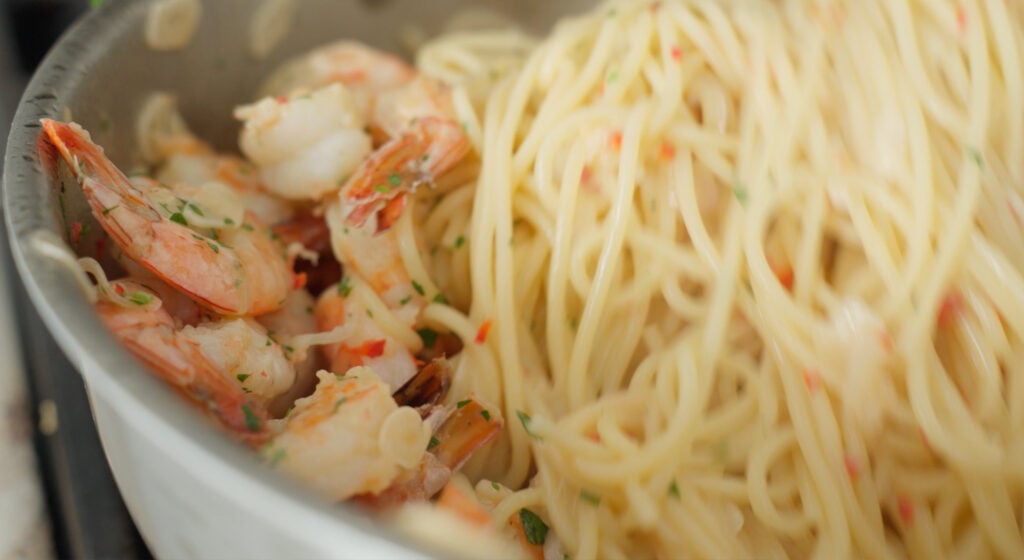 pasta and shrimp being mixed together