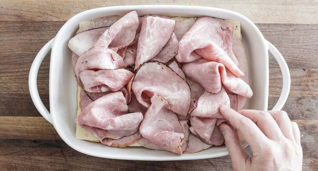 adding ham to cheese sliders and buns