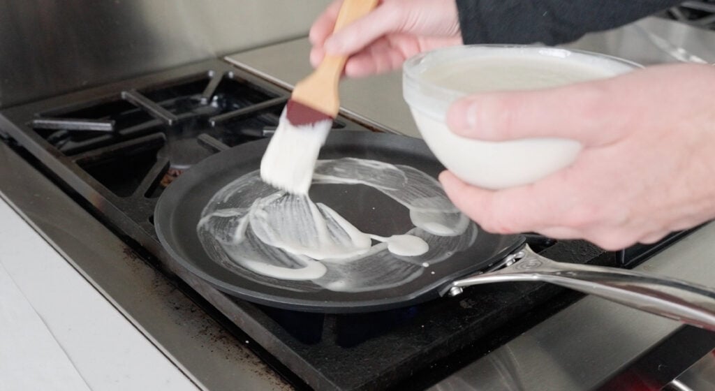 brushing batter on a hot skillet