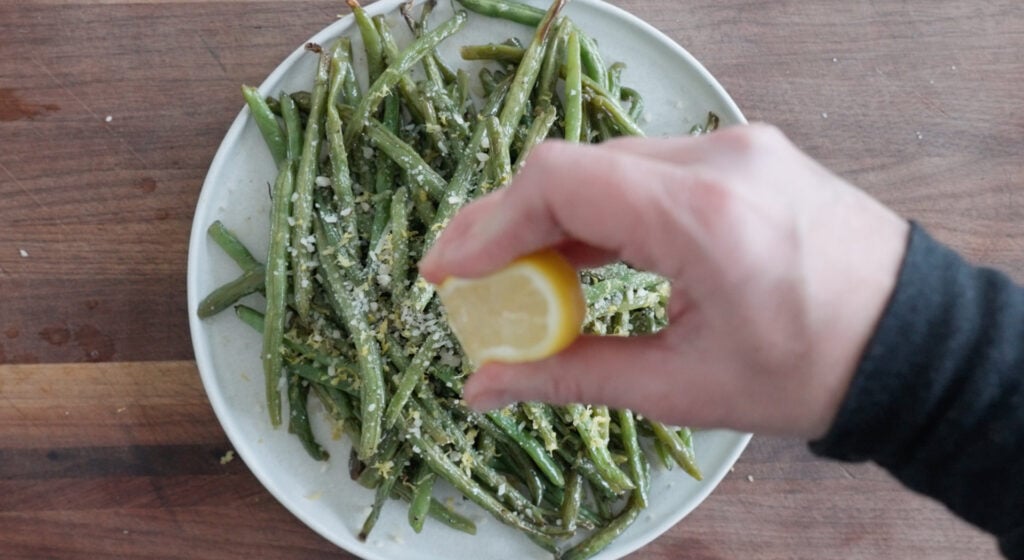 Oven Roasted Green Beans on serving plate with freshly squeezed lemon juice