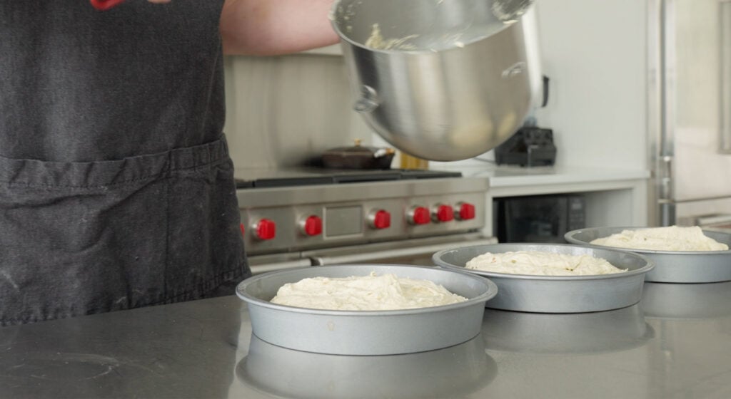 Cake batter divided between 3 cake tins