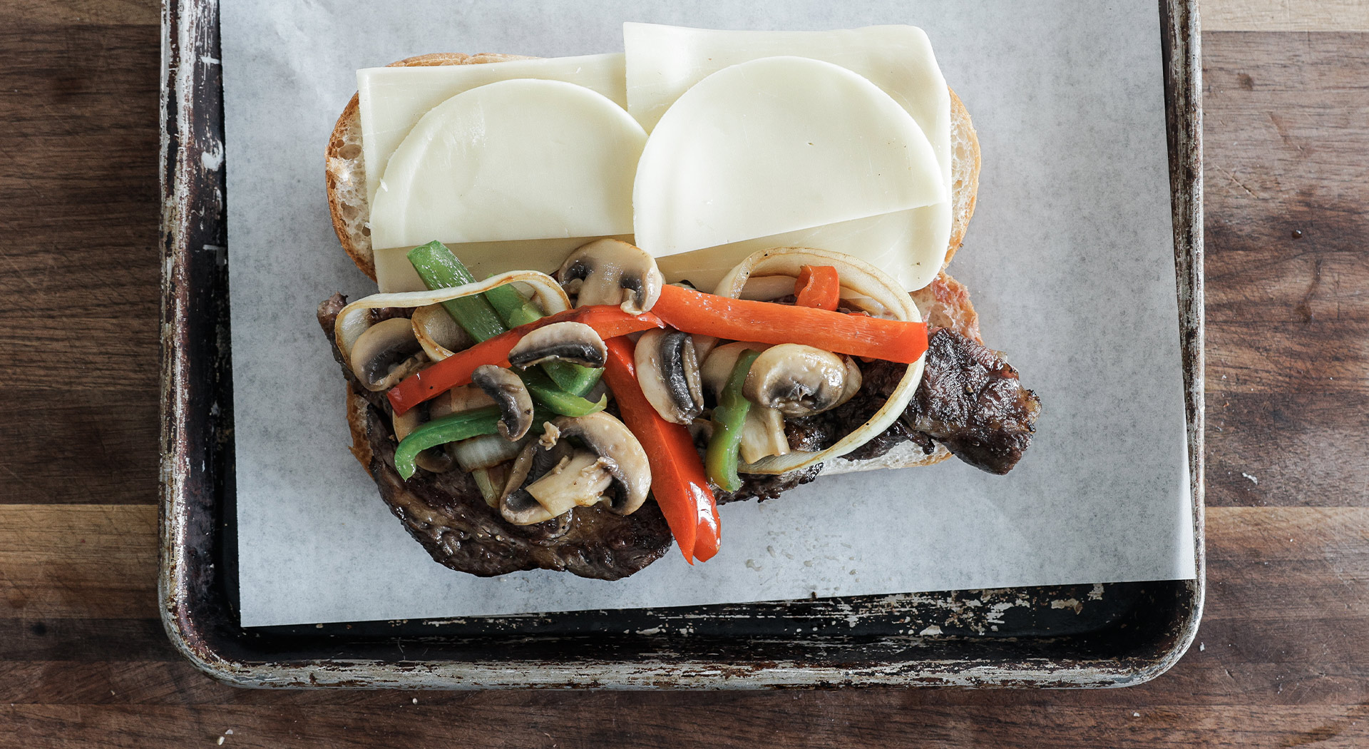 steak in a hoagie bun and layer on cheese, peppers, onions, and mushrooms.