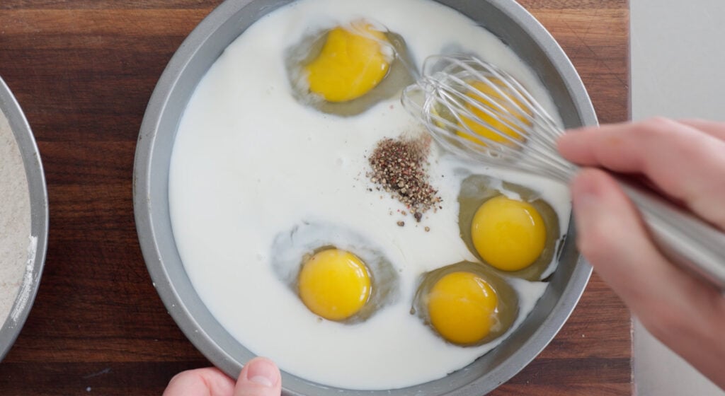 mixing eggs with milk in shallow dish for breading station