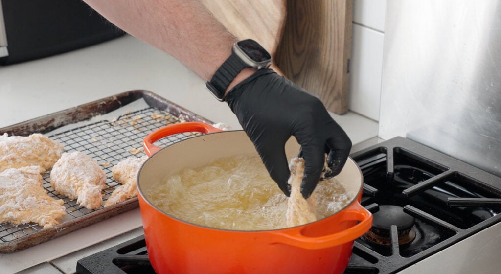 frying chicken in a pan of hot oil