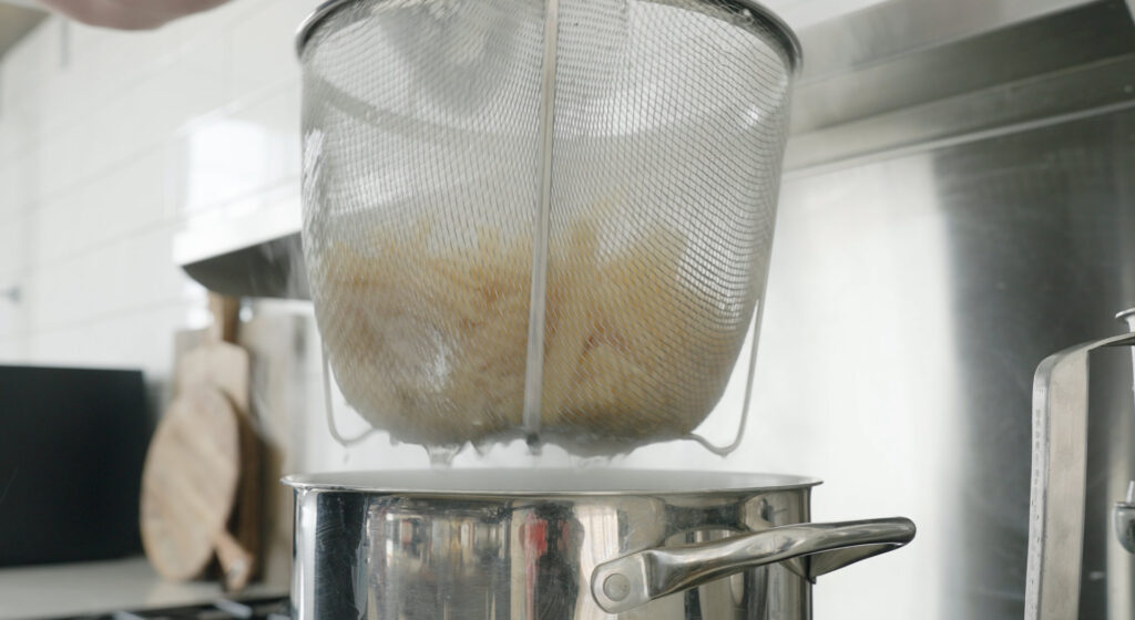 Cooked pasta in a strainer basket