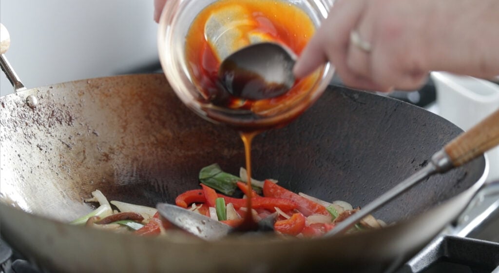 Add the sauce into the wok with veggies