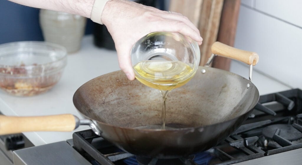 Add oil to a hot wok over high heat 