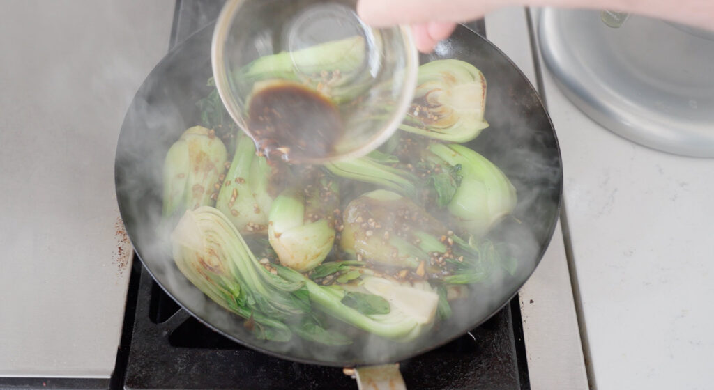 Adding sauce to bok choy