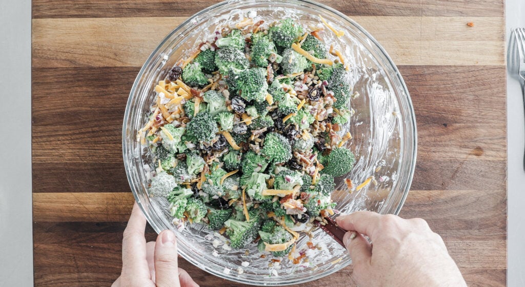 mixing a broccoli salad in a bowl
