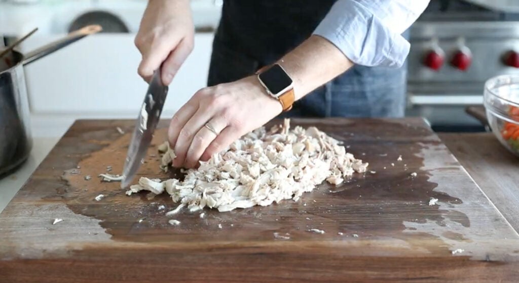 chopping the chicken into bite-size pieces