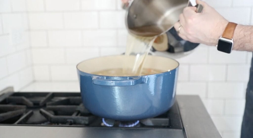 pouring the chicken broth into the pot