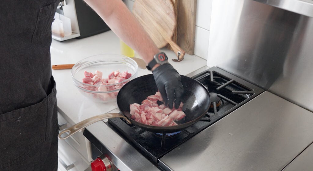 Pork cooking in a large wok