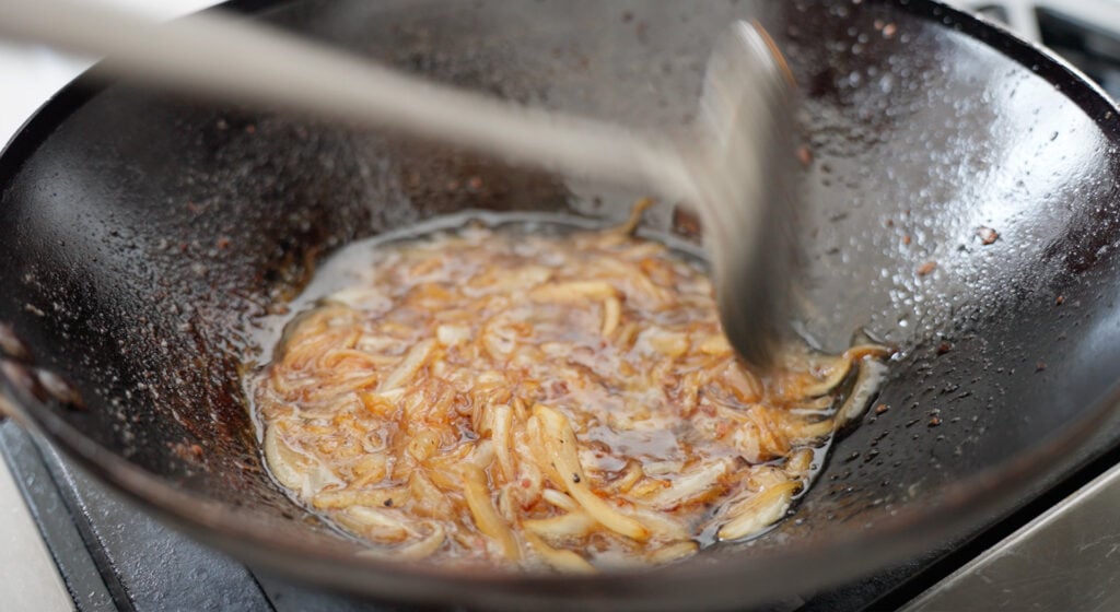 Brown onions in a wok