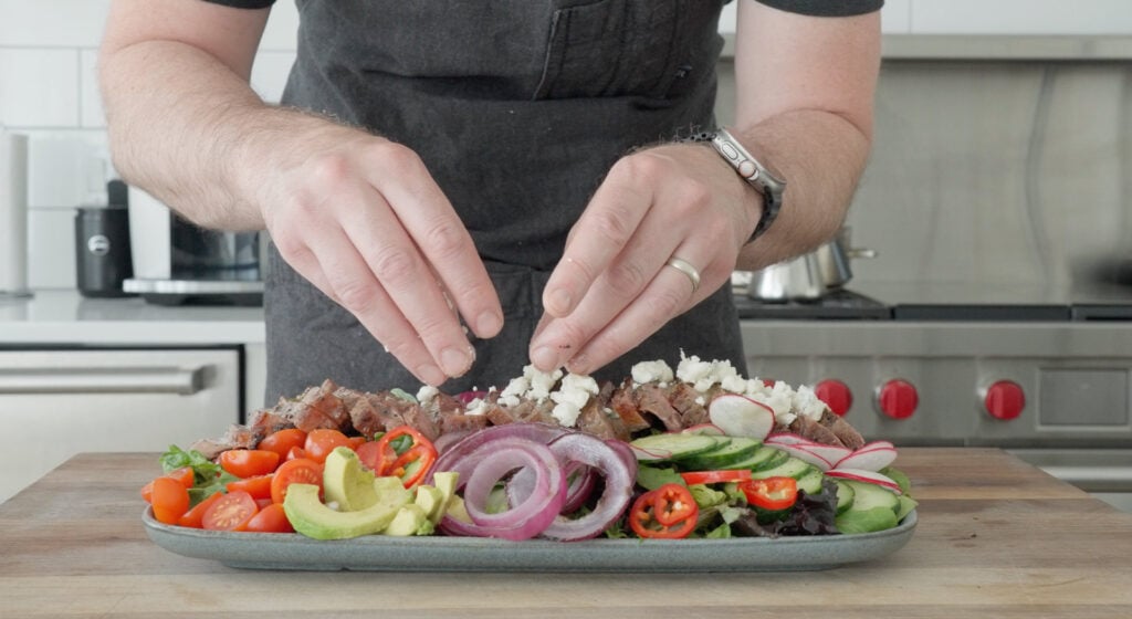 steak being added to salad