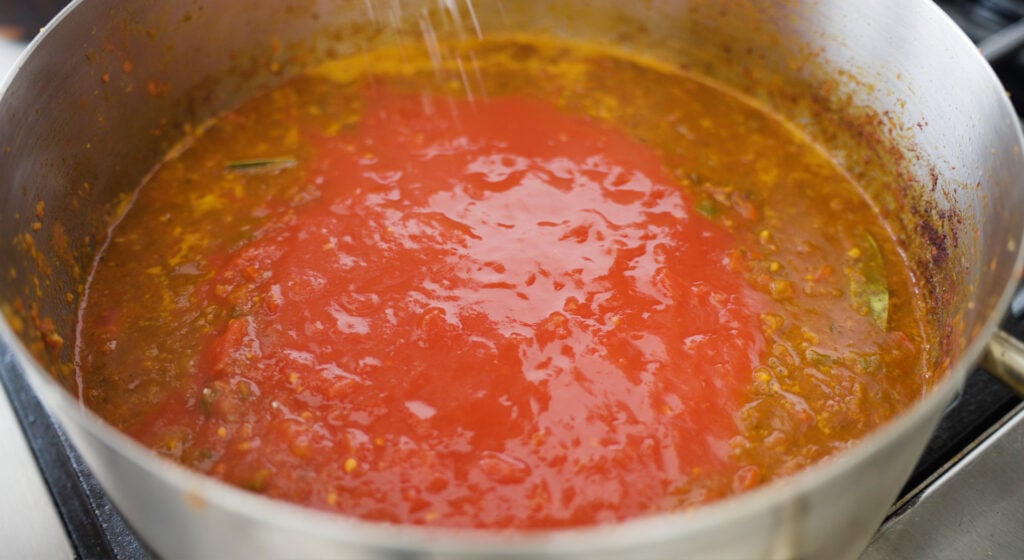 Diced and crushed tomatoes added to pot