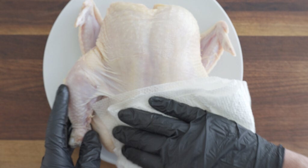 drying whole uncooked chicken with paper towel