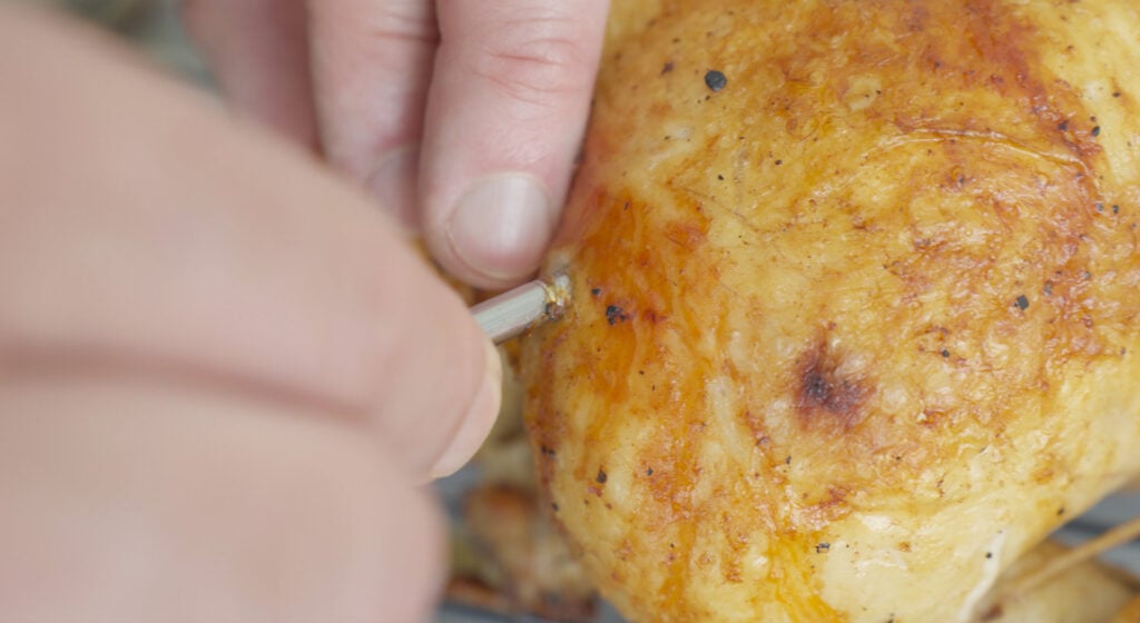 Removing thermometer from roasted chicken