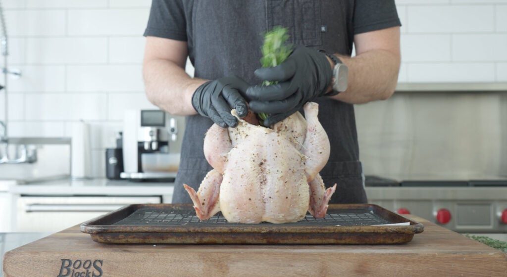 Chicken being stuffed with herbs