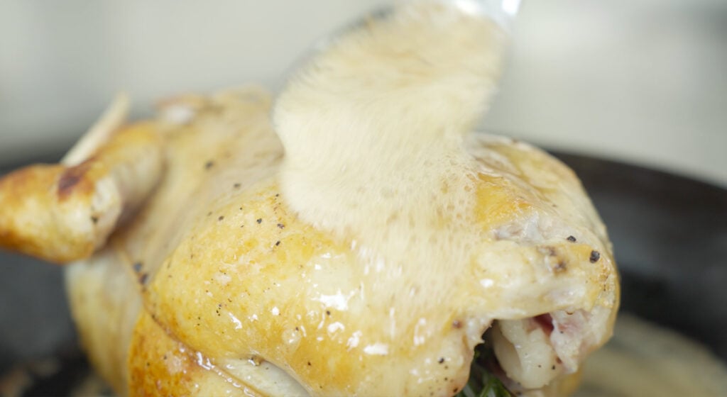 Basting chicken in a pan