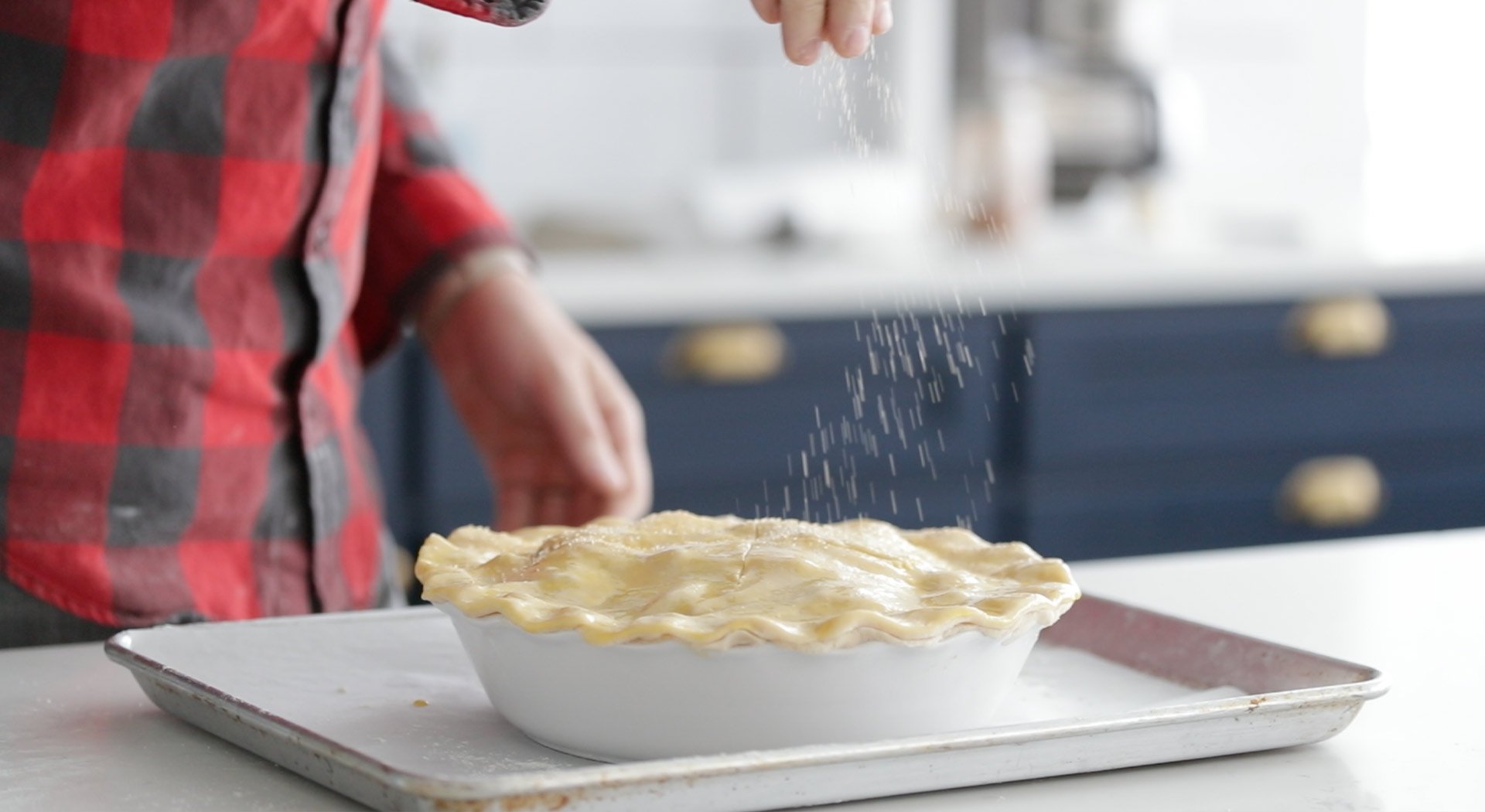 adding sugar to the top of an apple pie