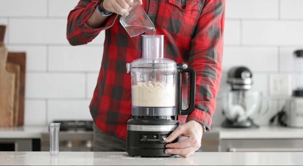 adding water to a pie dough