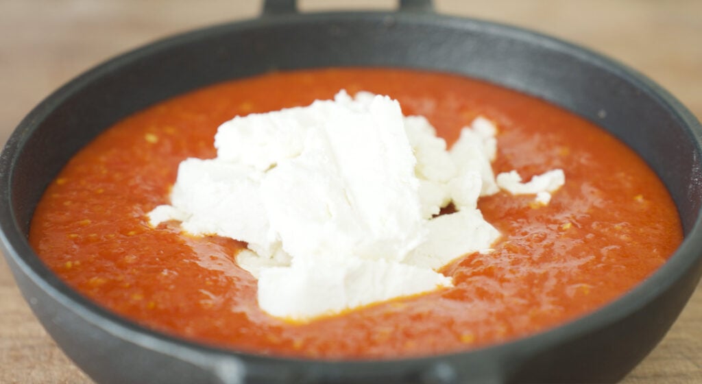Goat cheese spread over top of sauce