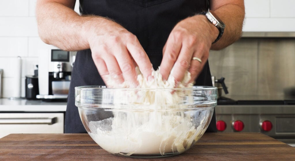Mixing biga ingredients in a bowl by hand