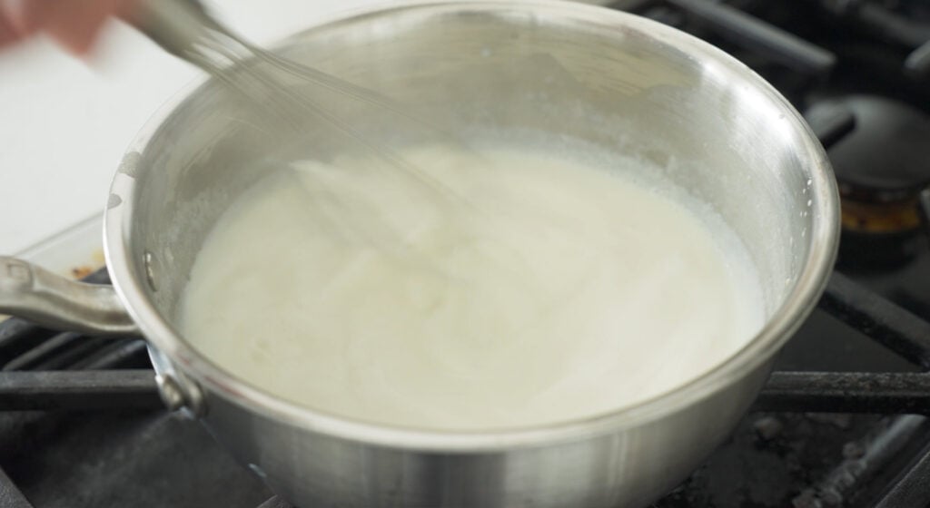 whisking milk in pan