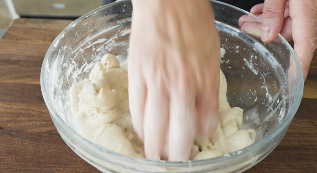 hand mixing dough ingredients in a bowl